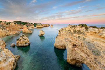 Fototapeta na wymiar Amazing sunset at Marinha Beach in the Algarve, Portugal. Landscape with strong colors of one of the main holiday destinations in europe. Summer tourist attraction.