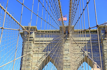 Obraz premium Zbliżenie na Brooklyn Bridge i American Flag nad East River, Nowy Jork, USA