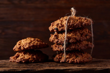 Conceptual composition with assortment of cookies and cinnamon with napkin on a wooden barrel, selective focus