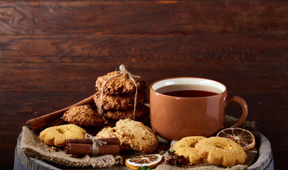 Cookies with cinnamon and two cups of tea on a burlap napkin, selective focus, close-up, top view.