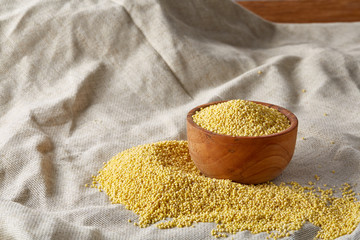Lentils in a wooden bowl on rustic wooden background, top view, close-up, selective focus.