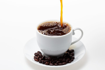 Pouring coffee into white coffee cup and beans on white background.