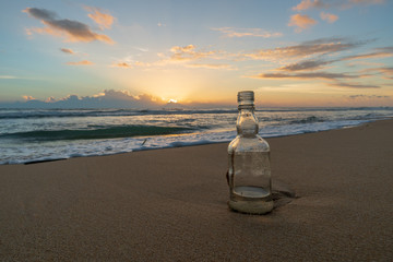 Glass bottle with beatiful beach sunset landscape