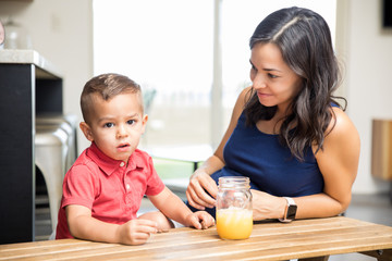 Pregnant Woman And Boy With Juice Jar On Table