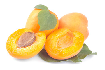 Ripe, fresh apricots and a half of apricot with a leaf on a white background isolated