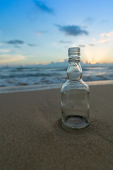 Glass bottle with beatiful beach sunset landscape