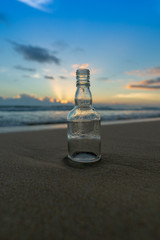 Fototapeta na wymiar Glass bottle with beatiful beach sunset landscape