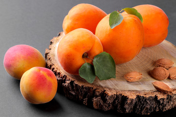 Fresh, ripe apricots on a wooden stand on a black background