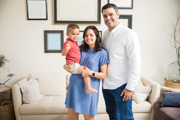 Smiling Pregnant Woman Carrying Son By Man At Home