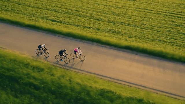 Tracking mid close shot of road bikers on the sunrise