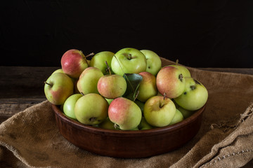 Ripe red and green apples on wooden background. Apples in bowl. Garden fruits. Autumn fruits. Autumn harvest.