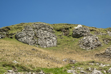 Large rock, with moss, on a field in Bucegi Mountains, Bucegi National Park, Romania