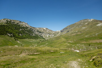 Fototapeta premium View of Bucegi Mountains, Bucegi National Park, Romania, clear blue sky, few clouds, sunny summer day, perfect for hiking