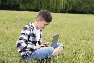 Smiling boy using modern laptop