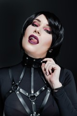Portrait of sensual young woman with bright makeup wearing harness belts