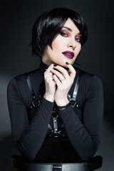 Portrait of sensual young woman with bright makeup wearing harness belts
