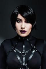 Portrait of sensual young woman with bright makeup wearing harness belts