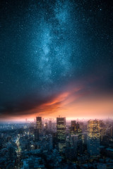 Milky way and dramatic clouds over city skyline at night