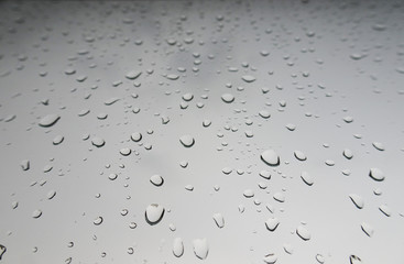 Large drops of rain on the windshield of the car