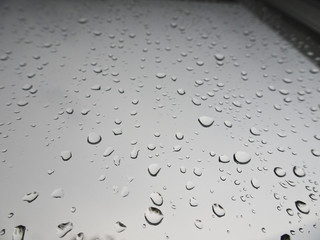 Large drops of rain on the windshield of the car
