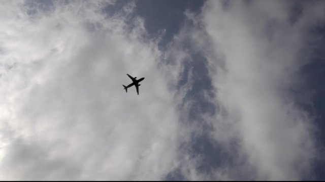 The plane flies against the sky from corner to corner of the frame.
