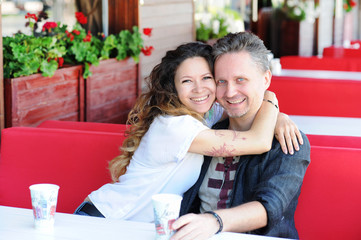 Smiling in love couple sitting in a street cafe