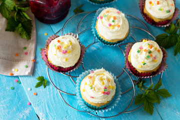 Birthday cupcake with buttercream icing and raspberry jam a wooden table. Copy space.