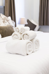 Fototapeta na wymiar White towel roll on hotel resort bed