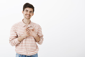 Touched to bottom of heart. Indoor shot of pleased caring handsome boyfriend with moustache and...