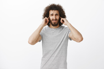 Man, your play is awful. Portrait of displeased uncomfortable attractive hispanic guy with beard...