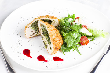 Breaded chicken fillet stuffed with spinach with fresh vegetables and herbs