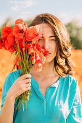 Beautiful woman with bouquet of poppies.