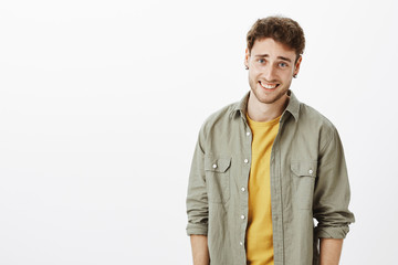 Waist-up shot of arrogant handsome and self-assured curly-haired male with bristle, laughing and...