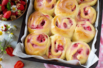Fresh Homemade Rolls Buns with strawberry with Cream Cheese in glaze for Breakfast close-up on a...