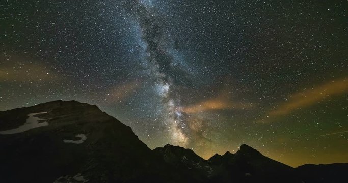 Astro Time Lapse Milky way galaxy stars rotating over the Alps, motion clouds, scenic mountain peak and cliff, Jupiter planet right and Mars planet left