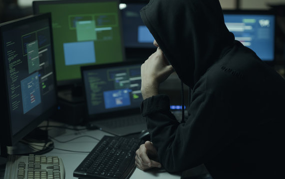 Hacker with hoodie working with a computer