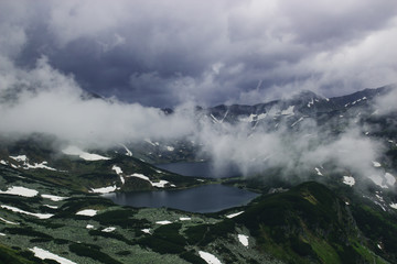 Beautiful gloomy scary mountain landscape with two lakes in the fog and snow