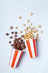 Sweet caramel chocolate popcorn in paper striped white red cup