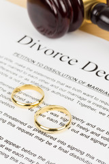 Wooden judge gavel, golden rings, and divorce decree; document is mock-up