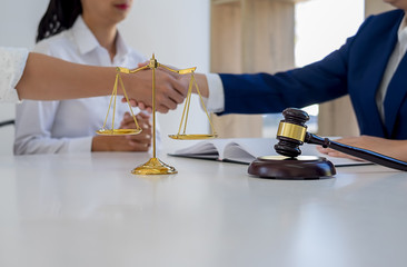 Judge gavel with Justice lawyers having team meeting at law firm in background. Concepts of law.