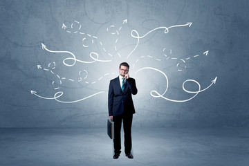 Elegant businessman choosing between directions with winding drawn arrows around 
