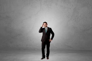 Obraz premium Alone handsome businessman standing in a dark empty room