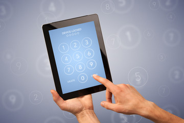 Female fingers touching tablet with locked device requiring passcode