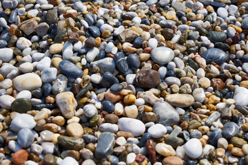 Pebbles on the beach as a natural background. 