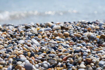 Pebble beach with blurred sea water on a background. 