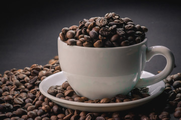 coffee in white cup and coffee beans are the background.