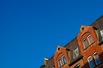 Gable of a red house in front of a clear blue sky in the summer