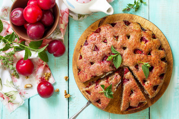 Delicious dessert plum pie, sweet delicious holiday cake with plums and nuts. Top view flat lay...