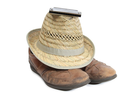 Harmonica and straw hat on a white background