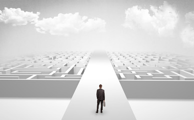 Businessman going straight ahead on a wide road between mazes
